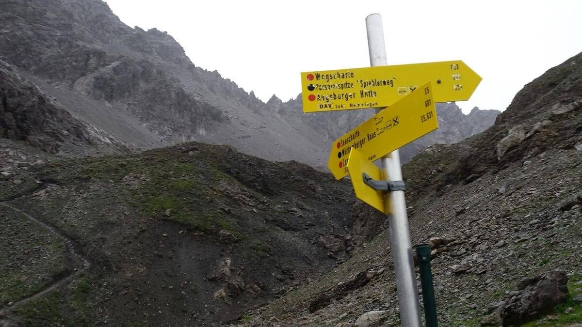 Wegweiser auf der E5-Alpenüberquerung an der Seescharte mit Richtungsangaben zur Augsburger Hütte und Winnebachseehütte