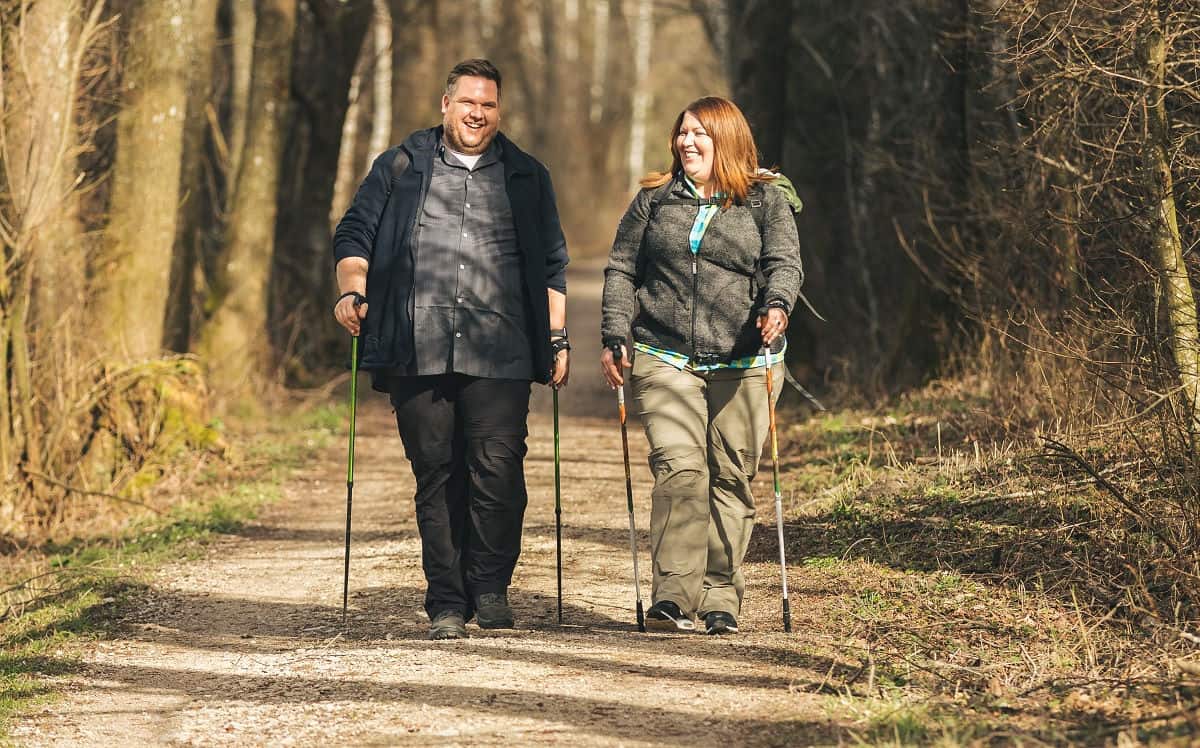 Zwei Personen in Übergröße beim Gehen auf einem Weg in der Natur