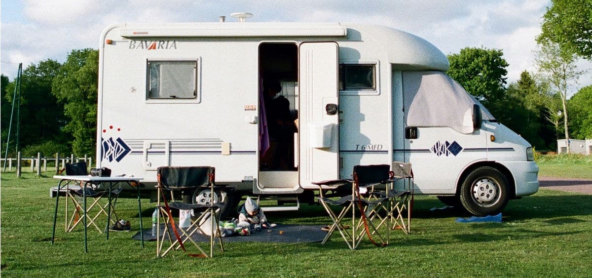 Wohnmobil auf dem Campingplatz mit Campingstühlen und Tisch – Packliste Wohnmobil