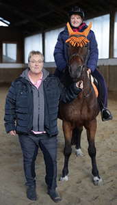 Reitbekleidung in großen Größen – Kundin in der Reithalle mit Pferd