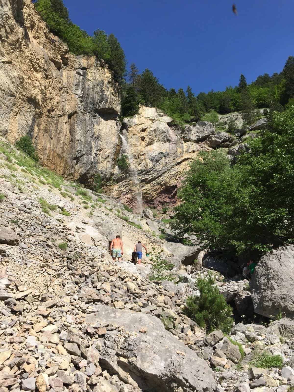 Wanderer im steilen Aufstieg durch ein Geröllfeld auf dem Peaks of the Balkans