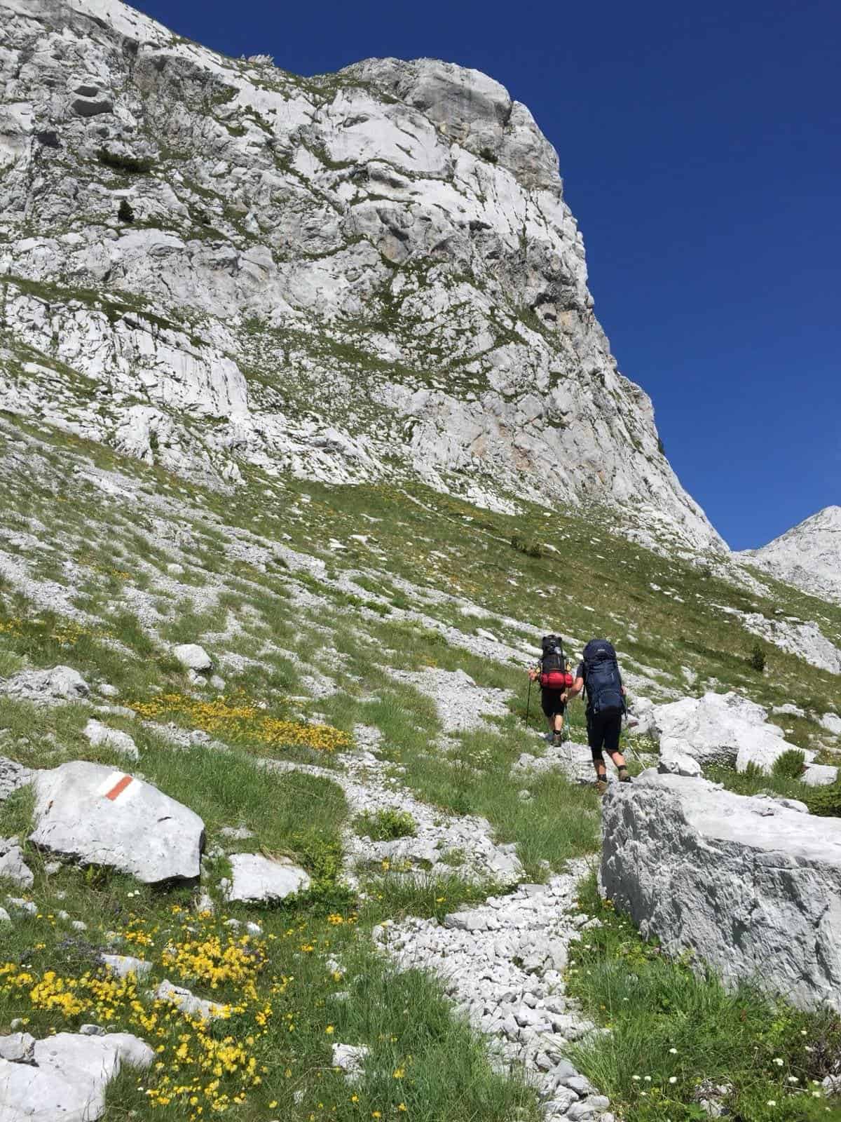 Wanderer mit großem Trekking-Rucksack im Aufstieg auf dem Peaks of the Balkans Trail