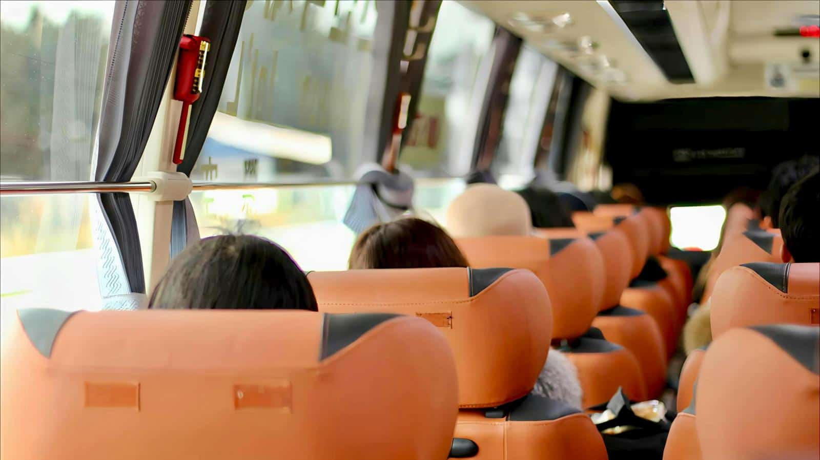 Blick durch die Sitzreihen in einem vollbesetzten Reisebus während einer Rundreise